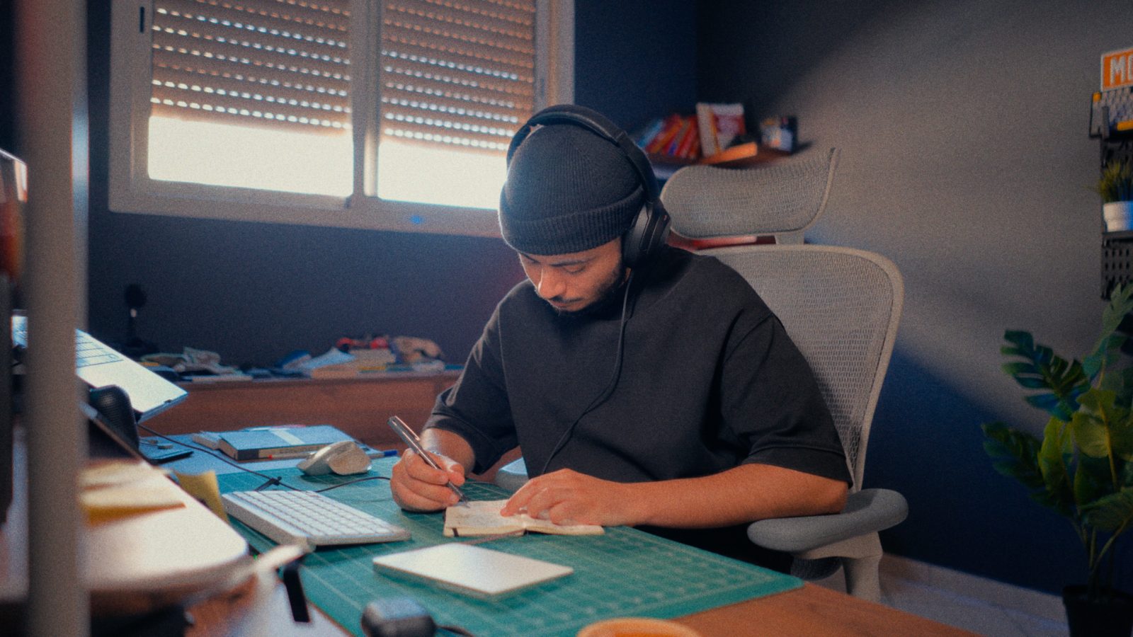 Youssef Toufik writing notes at his desk by window light